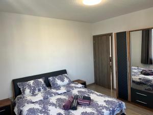 a bedroom with a bed with a blue and white comforter at ВИЛА НАНО 