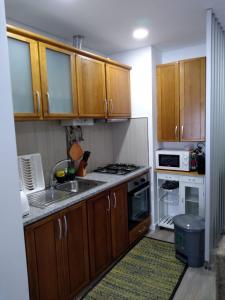 a kitchen with wooden cabinets and a stove top oven at Apartamento Balsa 2 in Viseu