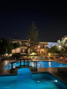 a large swimming pool at night with a resort at Marigianna in Gouves