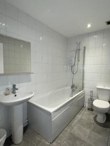 a bathroom with a tub and a sink and a toilet at Regent Apartments - Glasgow City Centre in Glasgow