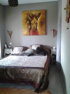ギソナクシアにあるVilla Laura avec Piscine Privéeのベッドルーム1室(壁に絵画が描かれたベッド1台付)