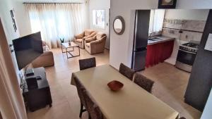 cocina y sala de estar con mesa y sillas en La Colina en Villa Carlos Paz
