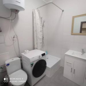een witte badkamer met een toilet en een wastafel bij Ideal for family and older pers. in Rīga