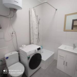 a white bathroom with a toilet and a sink at Simana 3A Ideal for family and older pers in Rīga