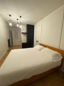 a bedroom with a large white bed with two lights at Camere La Meridiana in Domodossola