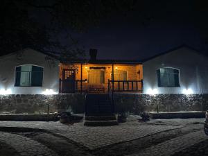 a house with lights on the front of it at night at Cabañas La lunada in Las Palomas