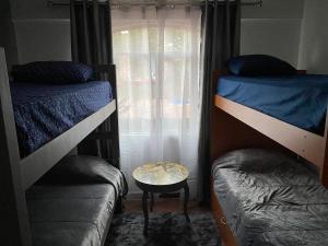 1 dormitorio con 2 literas y mesa en Cabañas La lunada, en Las Palomas