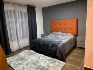 a bedroom with a bed and two rugs at Cabañas La lunada in Las Palomas