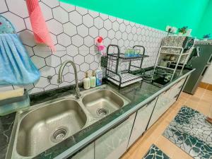 a kitchen counter with a sink in a kitchen at Dj Impiana Homestay @ Bukit Keluang Besut in Kampung Raja
