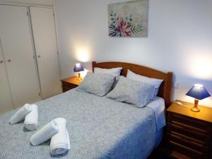 una camera da letto con un letto e due pantofole sopra di Apartamento Balsa a Viseu
