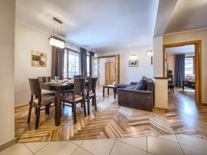 een eetkamer en een woonkamer met een tafel en stoelen bij VisitZakopane - Lemon Apartment in Zakopane