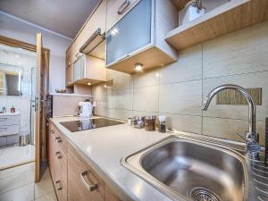 a kitchen with a stainless steel sink and wooden cabinets at VisitZakopane - Lemon Apartment in Zakopane