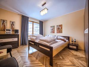 a bedroom with a large bed and a window at VisitZakopane - Lemon Apartment in Zakopane