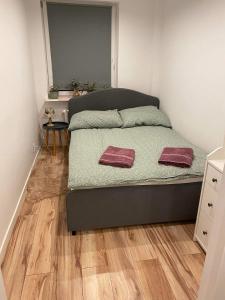 - une chambre avec un lit et 2 serviettes dans l'établissement Apartament w centrum miasta, à Suwałki