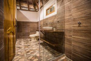 a bathroom with a toilet and a glass shower at Hotel MadreSierra Parque Tayrona in Calabazo