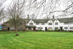 ein großes weißes Haus mit einem großen Rasenplatz in der Unterkunft Duke of York Cottage, Port Sunlight - Stanley-Stays in Wirral