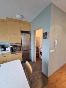 a kitchen with a table and a refrigerator at Eyjasol Apartments in Reykjavík