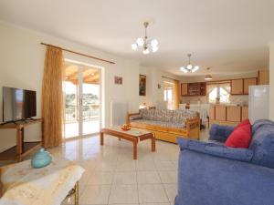 a living room with a blue couch and a kitchen at GM country house in Porto Rafti