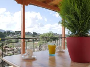 una mesa con un vaso de zumo de naranja en el balcón en GM country house en Porto Rafti