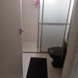 a bathroom with a shower and a black toilet at APTO FRENTE PARA MAR BOQUEIRÃO - PRAIA GRANDE in Praia Grande