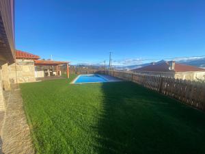 a backyard with a green lawn and a swimming pool at Refúgio do Vale in Celorico de Basto