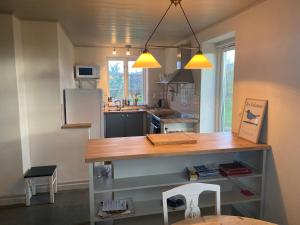 a kitchen with a table and a refrigerator at Eternellgården, Boende med självhushåll, nära Stenshuvuds Nationalpark in Kivik