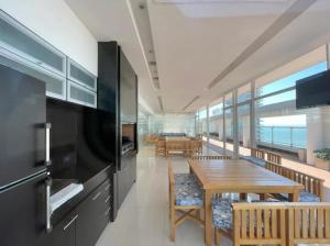 a dining room with a table and chairs and the ocean at deptomardel_playa in Mar del Plata