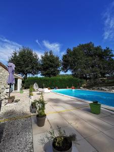 a swimming pool with a yellow hose next to it at DOMAINE DES 3 CYPRÈS Chambre MIMOSA Chez Nath & Pat in Fumel