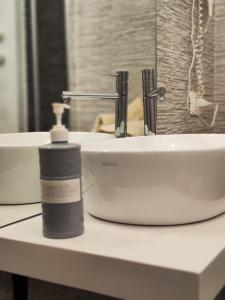 un lavandino in bagno con una bottiglia di sapone sul bancone di B&b La casett a Crotone