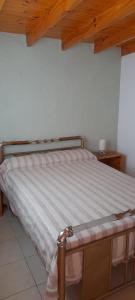 1 cama en un dormitorio con techo de madera en NOGOLI EL REMANSO, en San Luis