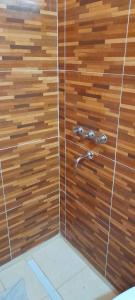 ducha con pared de madera y cabezal de ducha de metal en NOGOLI EL REMANSO en San Luis