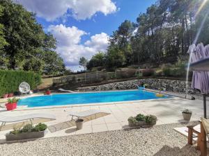 una piscina in un cortile con una montagna di DOMAINE DES 3 CYPRÈS Chambre MIMOSA Chez Nath & Pat a Fumel