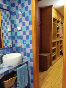 La salle de bains est pourvue d'un lavabo et d'un mur carrelé bleu. dans l'établissement Casa con encanto en el campo, à Pontevedra