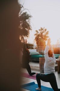 Dos personas haciendo yoga en una habitación en Vent Des Dunes, en Essaouira