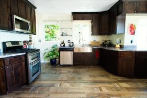 a kitchen with wooden cabinets and a wooden floor at Magical Bay View in Oakland Hills in Oakland
