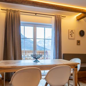 a dining room with a table and chairs and a large window at Haus Stangl in Bad Aussee