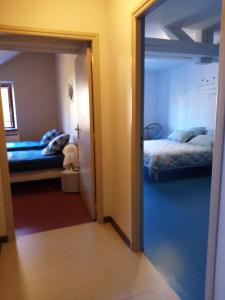 a door to a room with two beds and a mirror at Auberge du Marronnier in Belmont-sur-Rance