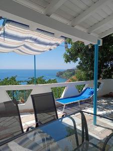 a table and chairs on a patio with a view of the ocean at Giota & Antonia Apartments in Koroni