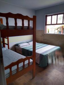 a bedroom with two bunk beds and a window at Casas da Dalma in Farol de Santa Marta