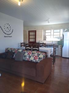 a living room with a couch and a kitchen at Casas da Dalma in Farol de Santa Marta