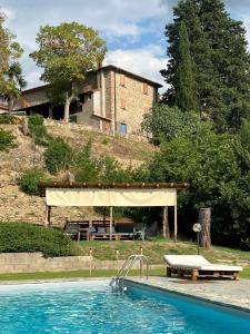 a swimming pool with a pavilion and a house at Stanze Blu in Subbiano
