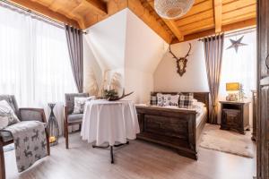 a room with a table and chairs and a room with a bed at Willa Mały Dworek in Zakopane