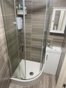 a shower with a glass door in a bathroom at Studio Apartment in Seven Sisters in London