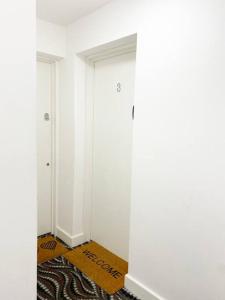 a hallway with a white door and a rug at Studio Apartment in Seven Sisters in London