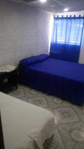 1 dormitorio con 2 camas y cortina azul en ESTABLECIMIENTO LA GEORGI en Luján de Cuyo