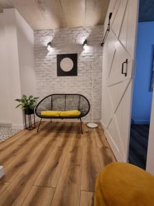 a yellow bench in a room with a brick wall at Apartament Wyspiański in Sanok