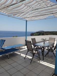 a patio with a table and chairs on a roof at Giota & Antonia Apartments in Koroni