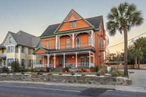 an orange house with a palm tree in front of it at Celestine Bed and Breakfast in Pensacola