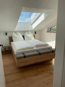 a bedroom with a large bed with a skylight at Die Römer in Schwaigern