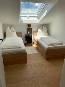 two beds in a room with a skylight at Die Römer in Schwaigern